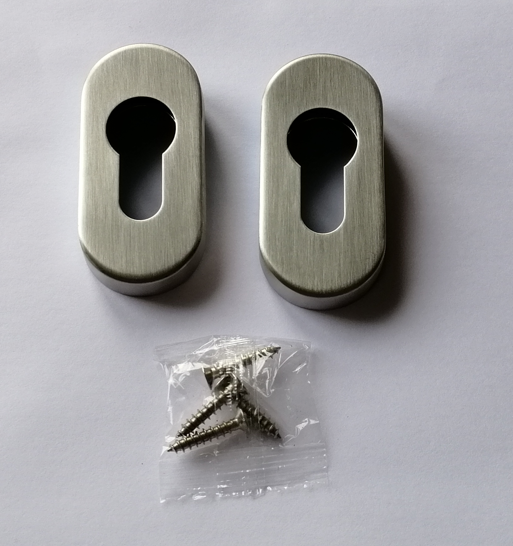 Brushed stainless steel oval escutcheon for a cylinder lock Brushed stainless steel oval escutcheon for a cylinder lock